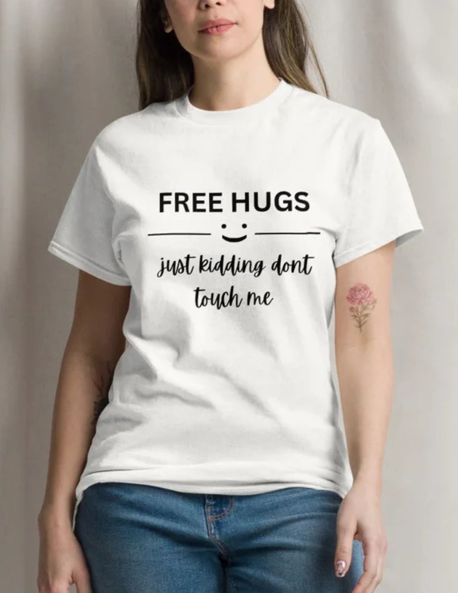 Person wearing a white t-shirt with 'Free hugs just kidding don't touch me' text.