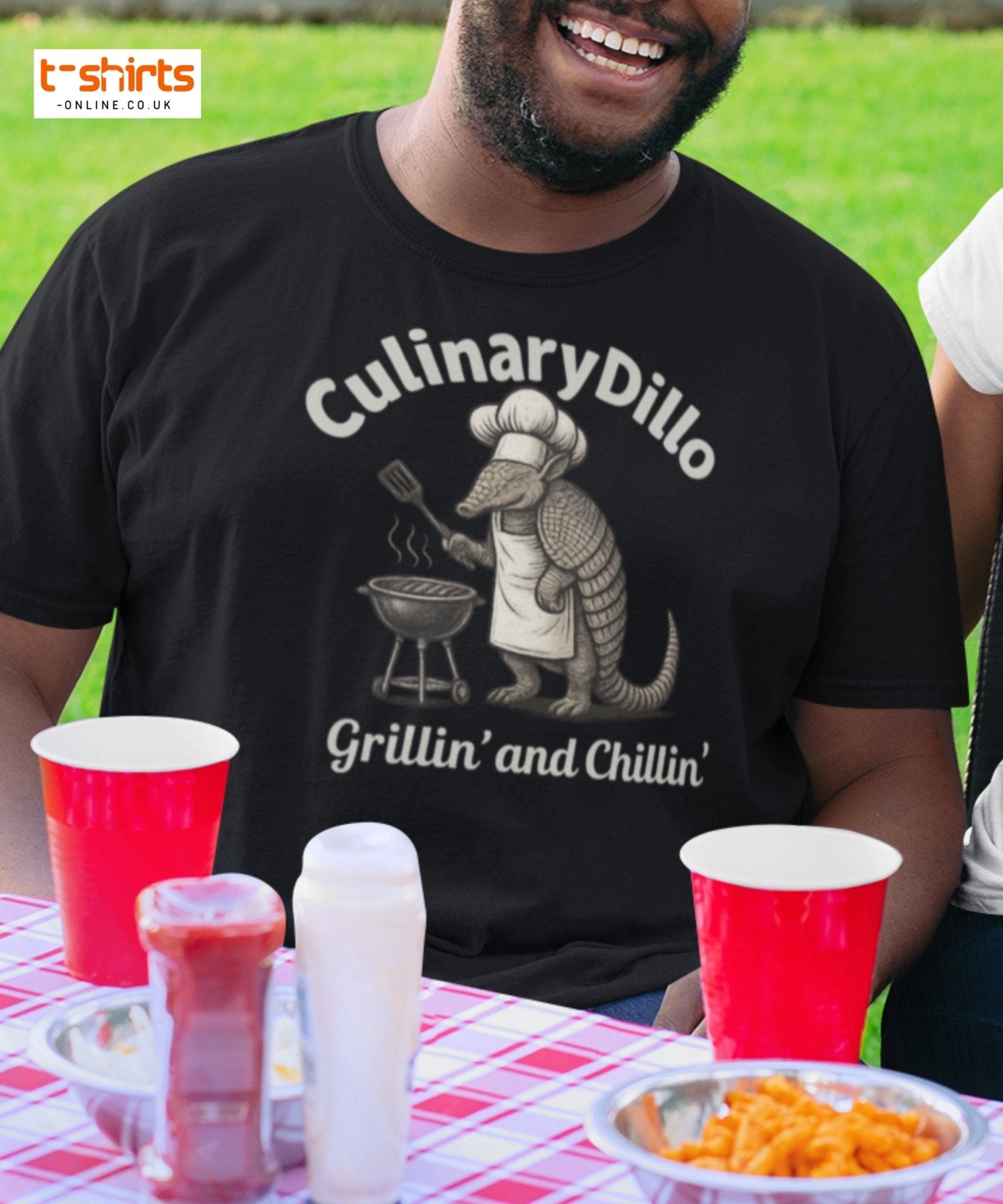 Man wearing a black t-shirt with 'CulinaryDillo' design at a picnic table.