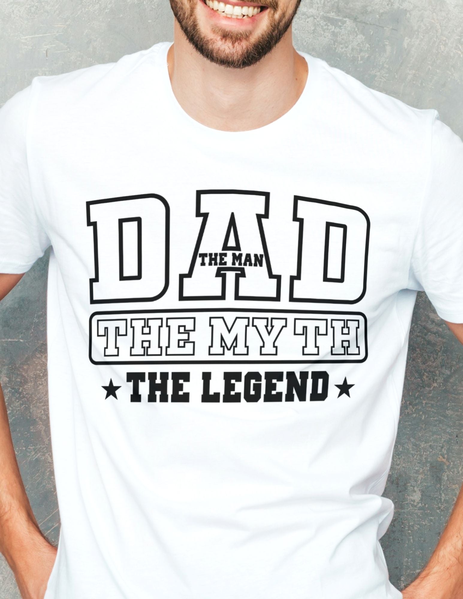 Man wearing a white T-shirt that reads “Dad – The Man, The Myth, The Legend” in bold varsity-style black text.