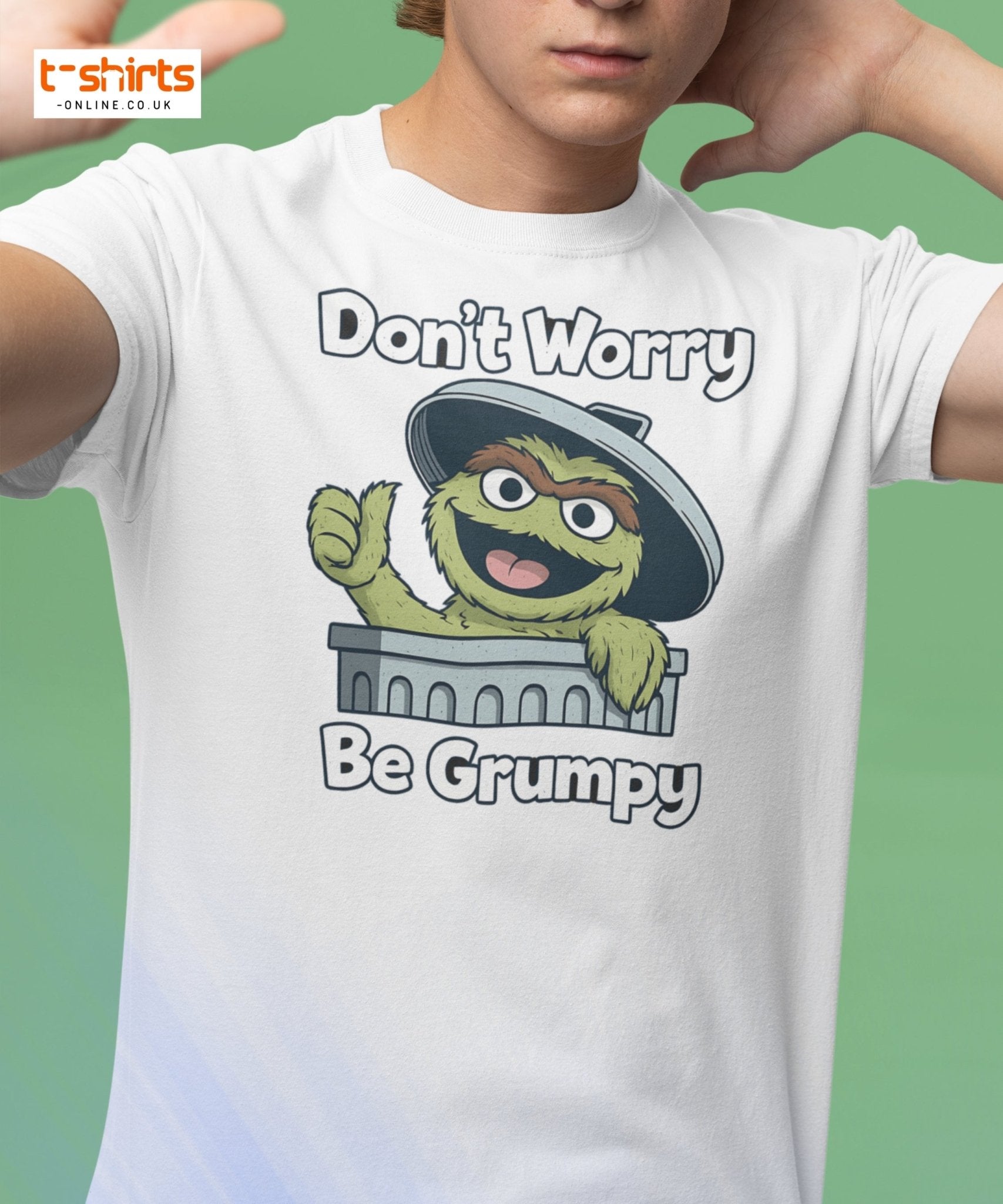 Person wearing a white t-shirt with a cartoon character and text 'Don't Worry Be Grumpy' on a green background.