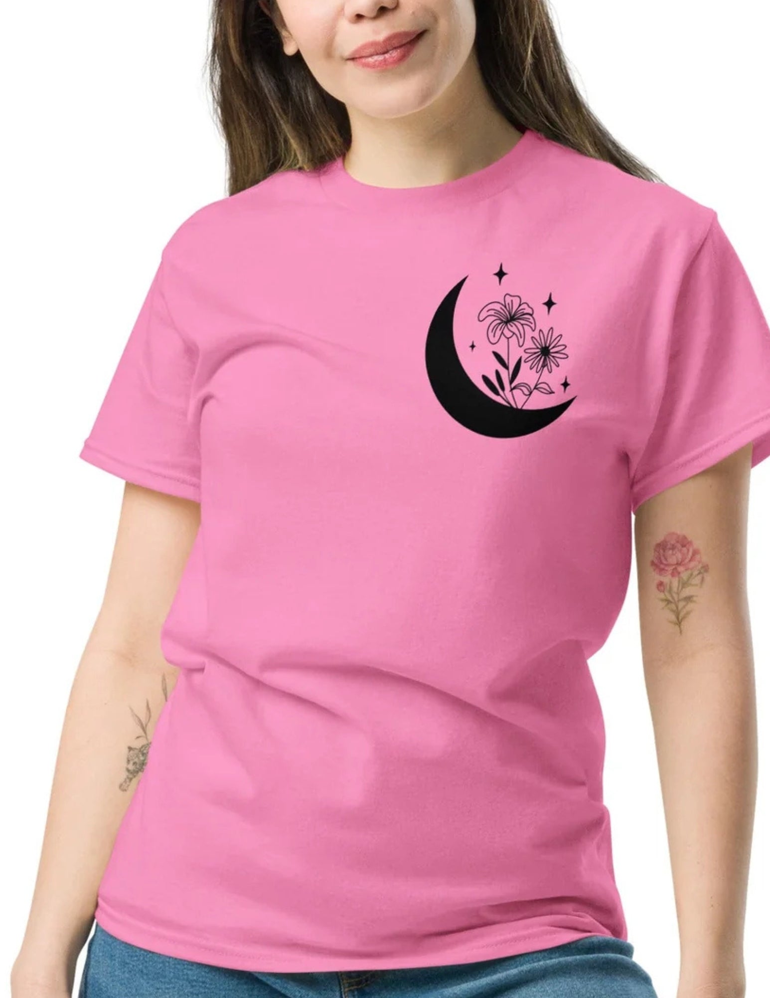 Pink t-shirt featuring a black crescent moon with flowers and stars printed on the chest area for a dreamy, celestial look.