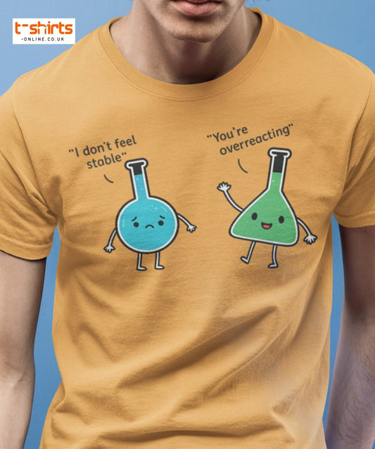Person wearing a mustard yellow t-shirt with cartoon flasks and text on a blue background