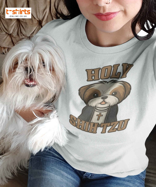 Person wearing a t-shirt with a dog graphic and text, sitting next to a small white dog.