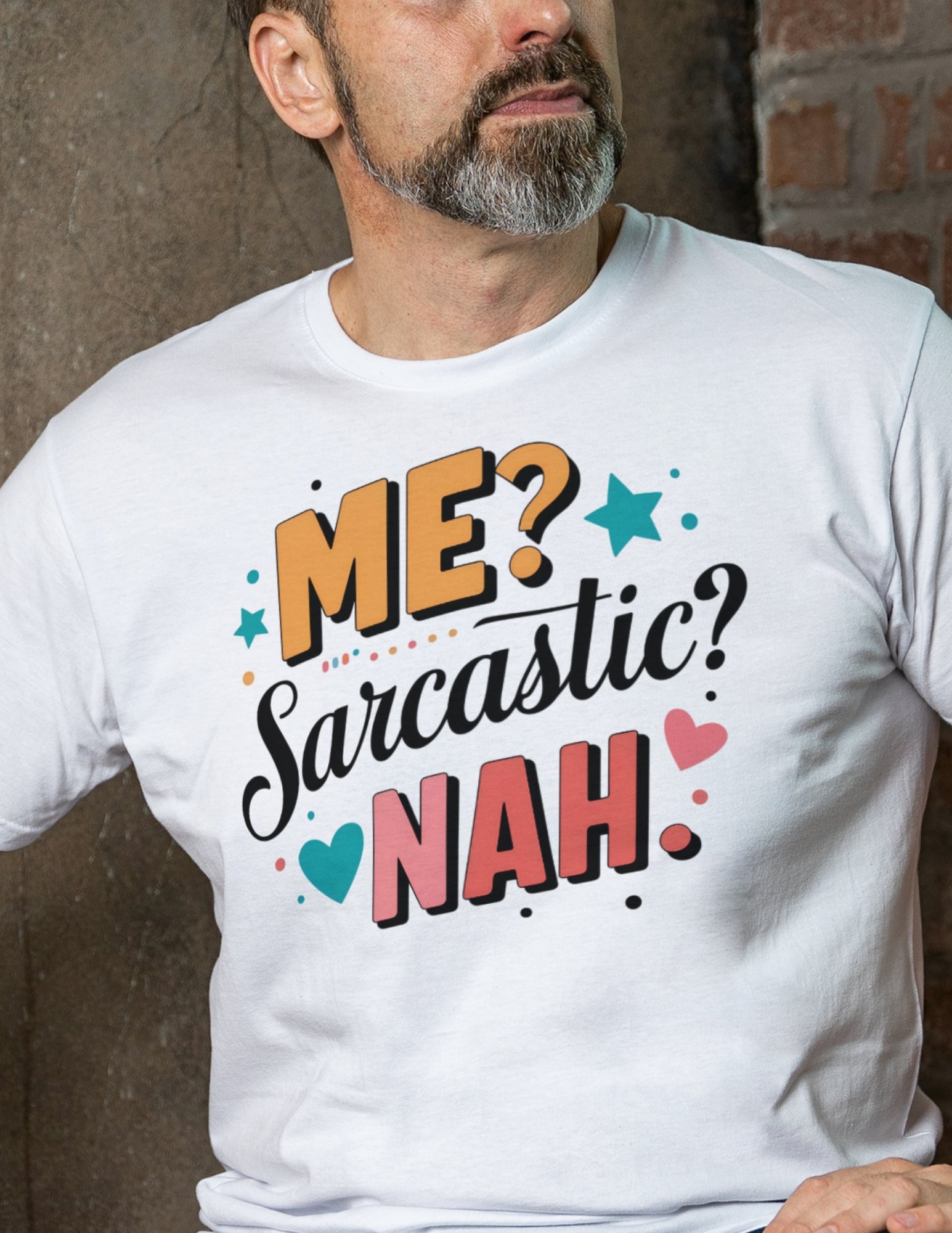 Man wearing a white t-shirt with colorful text reading “Me? Sarcastic? Nah.” in playful fonts with stars and hearts.
