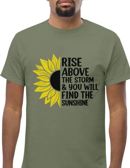 Green t-shirt with a half sunflower and motivational quote “Rise above the storm & you will find the sunshine” in black text.