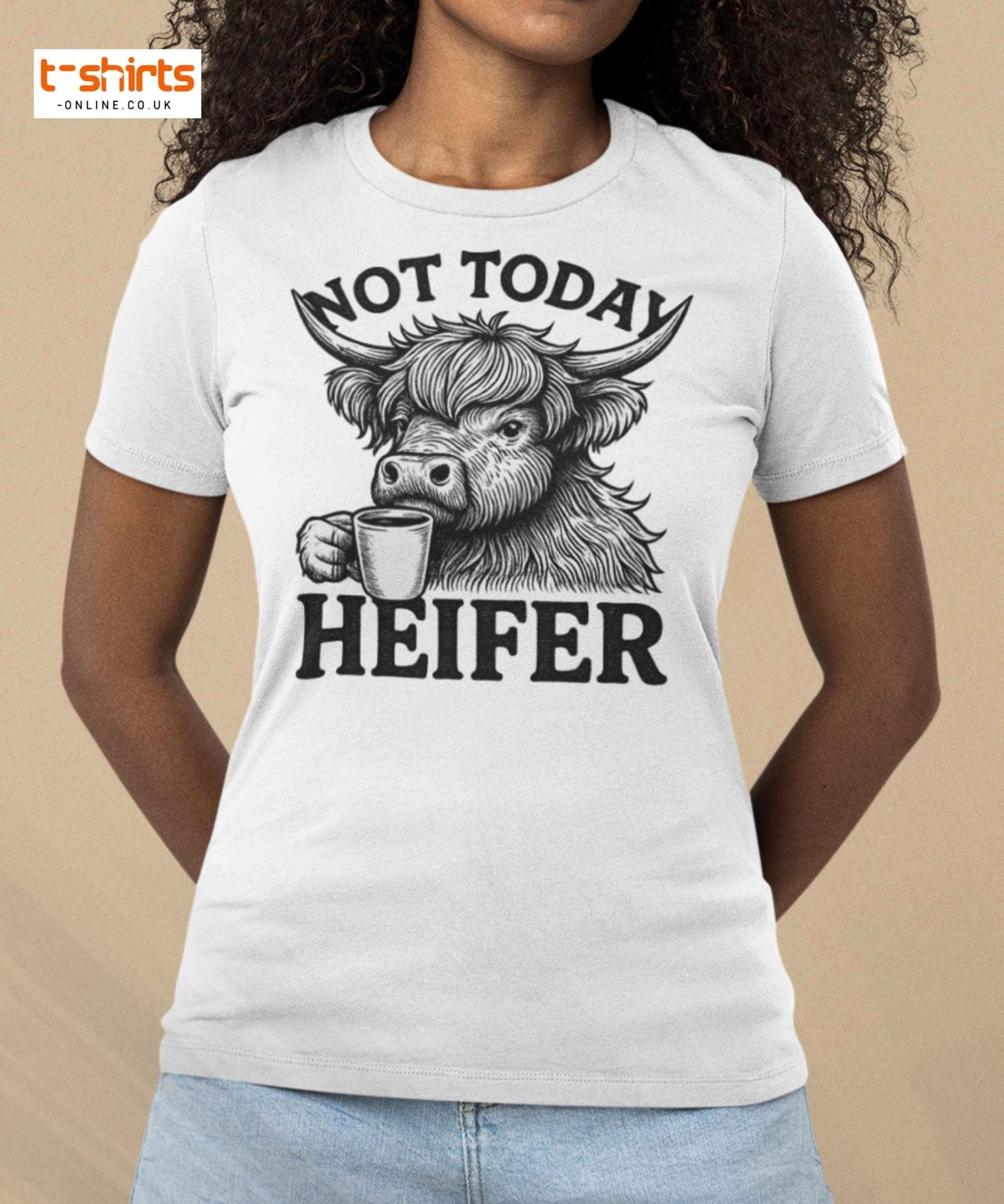 Person wearing a white t-shirt with a graphic of a cow holding a coffee cup and text 'Not Today Heifer' on beige background.