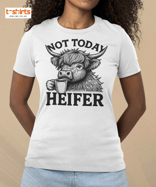Person wearing a white t-shirt with a graphic of a cow holding a coffee cup and text 'Not Today Heifer' on beige background.