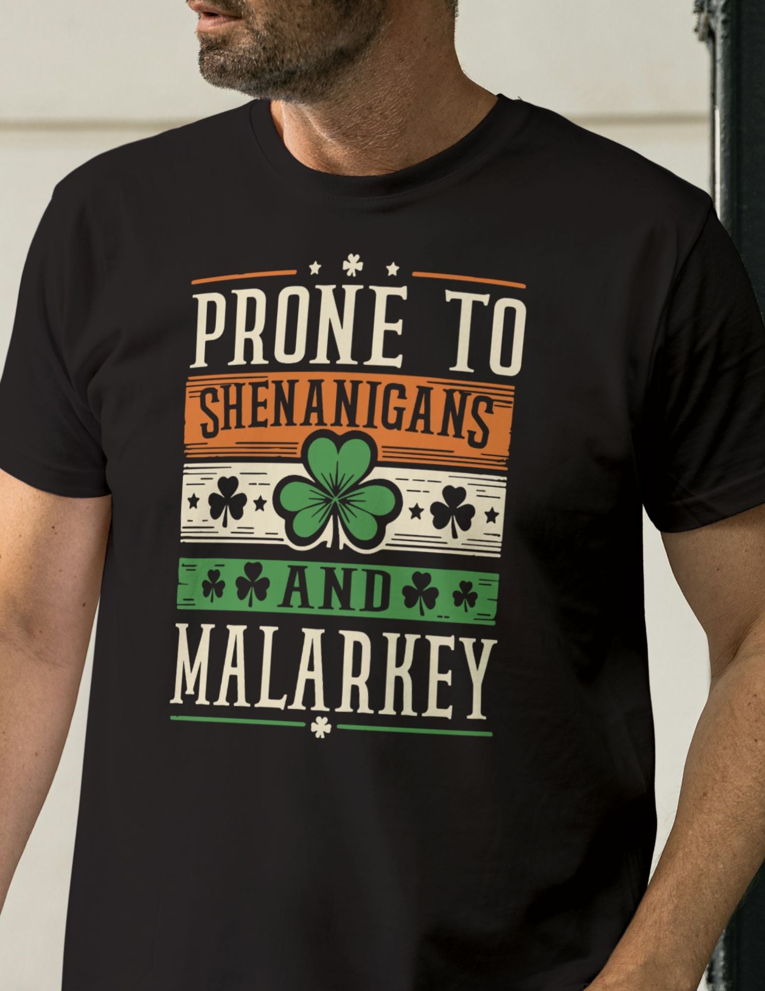 Black t-shirt with bold Irish-themed text reading “Prone to Shenanigans and Malarkey” and shamrock icons