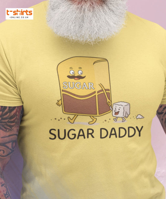 Yellow t-shirt with cartoon sugar bag and text 'Sugar Daddy' on a light purple background.